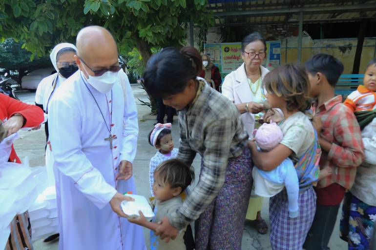 Archbishop Marco Tin Win is giving chicken pilau rice to the street vendors on Christmas day